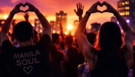 Crowd making heart shapes at sunset